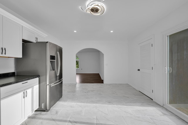 875-883 State Route T, West Plains, MO 65775 - kitchen with arched walkways, stainless steel fridge with ice dispenser, dark countertops, white cabinetry, and light marble finish floors