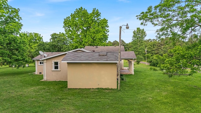 875-883 State Route T, West Plains, MO 65775 - view of side of property featuring stucco siding, roof with shingles, and a lawn