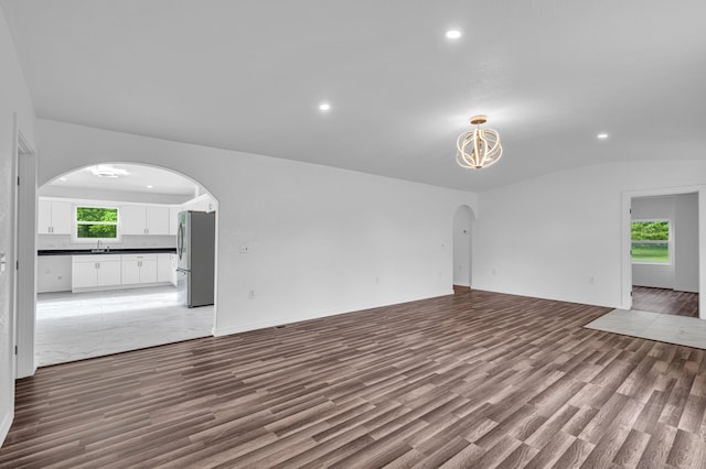 875-883 State Route T, West Plains, MO 65775 - unfurnished living room with wood finished floors, arched walkways, recessed lighting, a chandelier, and a sink