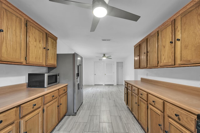 875-883 State Route T, West Plains, MO 65775 - kitchen with appliances with stainless steel finishes, ceiling fan, brown cabinets, and light countertops