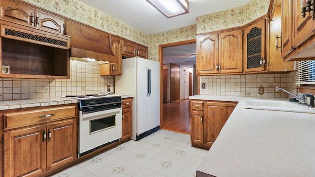 619 E Mcgee St Lot 15, Springfield, MO 65807 - kitchen featuring white appliances, wallpapered walls, a sink, light flooring, and brown cabinetry