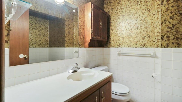 619 E Mcgee St Lot 15, Springfield, MO 65807 - bathroom featuring wallpapered walls, toilet, vanity, a wainscoted wall, and tile walls