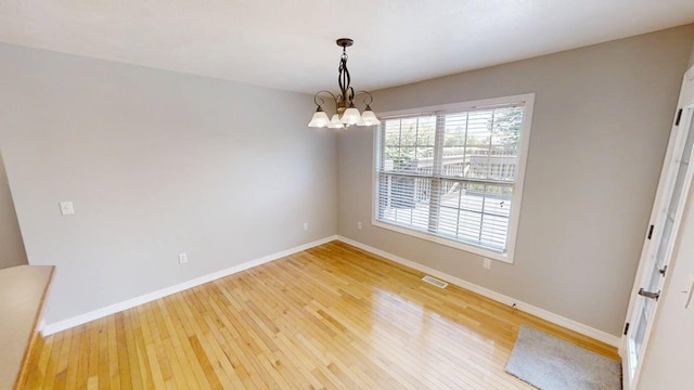 780 S Timber Ridge Dr, Nixa, MO 65714 - spare room featuring a chandelier, baseboards, and light wood-type flooring