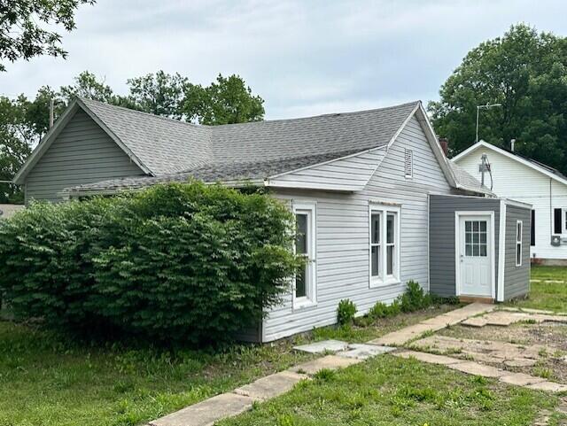 627 W Cherry St, Nevada, MO 64772 - view of side of property with roof with shingles