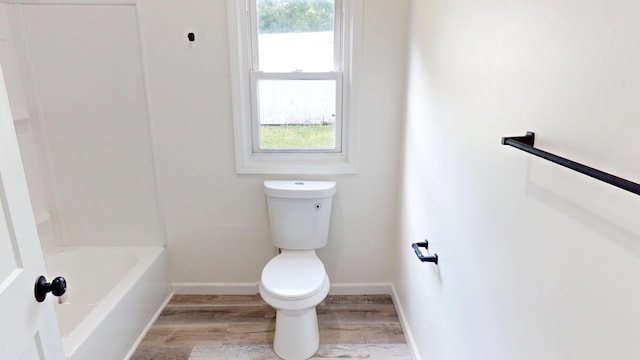627 W Cherry St, Nevada, MO 64772 - bathroom featuring toilet, wood finished floors, and baseboards