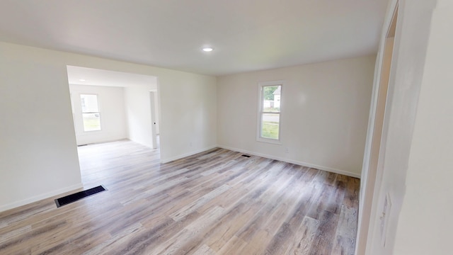 627 W Cherry St, Nevada, MO 64772 - empty room with healthy amount of natural light, light wood-style floors, baseboards, and recessed lighting