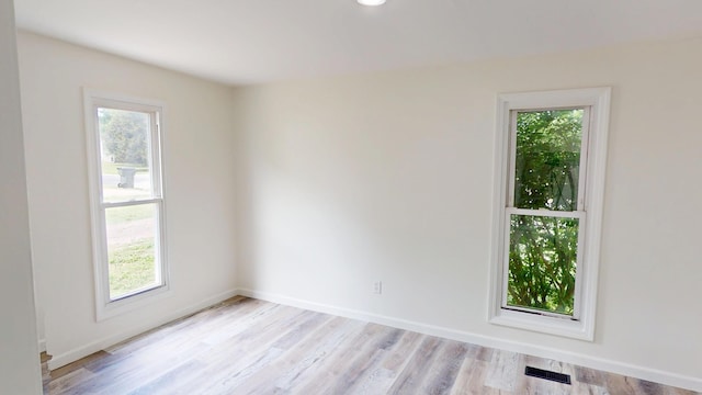 627 W Cherry St, Nevada, MO 64772 - empty room with plenty of natural light, light wood-type flooring, and baseboards