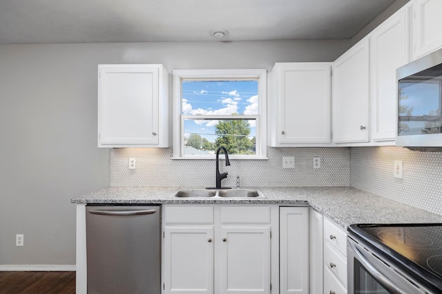 617 E SE Hills Ct, Nixa, MO 65714 - kitchen with appliances with stainless steel finishes, a sink, decorative backsplash, white cabinetry, and dark wood-style flooring