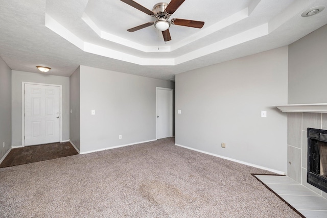 617 E SE Hills Ct, Nixa, MO 65714 - unfurnished living room with a tile fireplace, carpet floors, a ceiling fan, and a tray ceiling