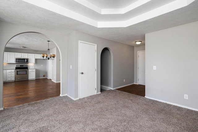 617 E SE Hills Ct, Nixa, MO 65714 - unfurnished room with dark carpet, arched walkways, baseboards, a chandelier, and a textured ceiling