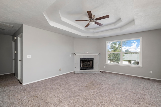 617 E SE Hills Ct, Nixa, MO 65714 - unfurnished living room featuring a textured ceiling, a raised ceiling, carpet floors, a fireplace, and a ceiling fan