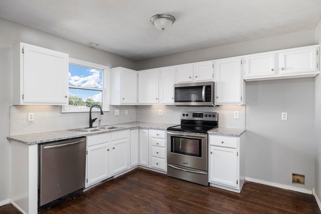617 E SE Hills Ct, Nixa, MO 65714 - kitchen with stainless steel appliances, a sink, dark wood finished floors, white cabinetry, and light stone countertops