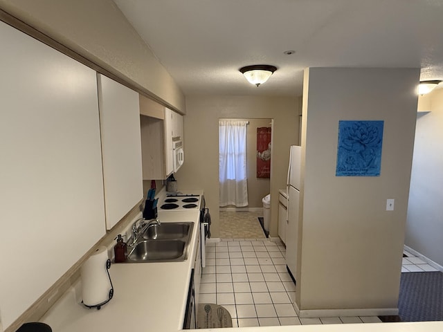 132 Highland Dr Unit 2, Branson, MO 65616 - kitchen with a sink, white appliances, white cabinets, light tile patterned floors, and baseboards