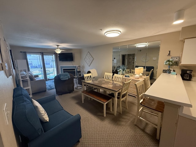 132 Highland Dr Unit 2, Branson, MO 65616 - dining space with carpet floors, a ceiling fan, and a fireplace
