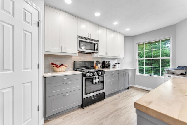 1108 E Robin St, Ozark, MO 65721 - kitchen with stainless steel appliances, gray cabinetry, light wood-style flooring, decorative backsplash, and baseboards