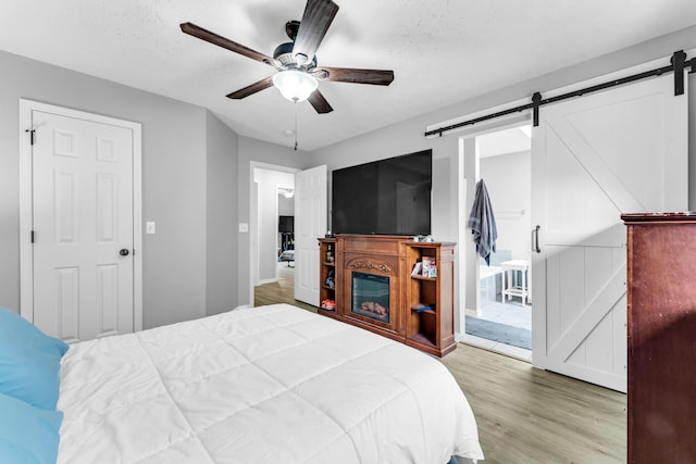 1108 E Robin St, Ozark, MO 65721 - bedroom featuring a barn door, wood finished floors, and a ceiling fan