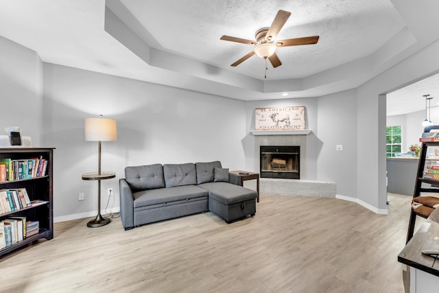1108 E Robin St, Ozark, MO 65721 - living area with a raised ceiling, ceiling fan, light wood-type flooring, baseboards, and a textured ceiling