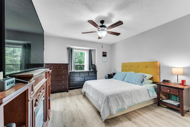 1108 E Robin St, Ozark, MO 65721 - bedroom with multiple windows, light wood-style floors, a textured ceiling, and a ceiling fan