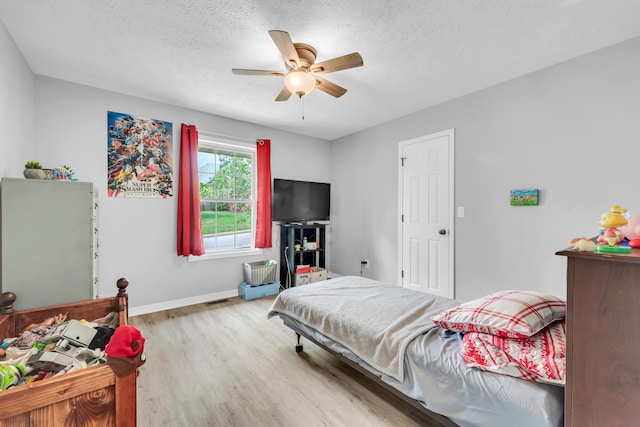 1108 E Robin St, Ozark, MO 65721 - bedroom featuring wood finished floors, a textured ceiling, baseboards, and a ceiling fan