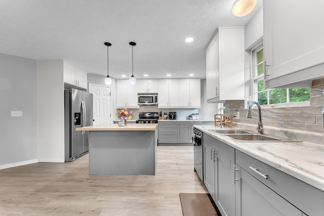 1108 E Robin St, Ozark, MO 65721 - kitchen featuring stainless steel appliances, a sink, gray cabinetry, baseboards, and backsplash