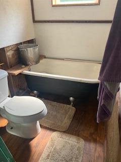 20001 Clear Lake Ter, Winona, MO 65588 - bathroom featuring wood finished floors, a soaking tub, toilet, and healthy amount of natural light