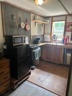 20001 Clear Lake Ter, Winona, MO 65588 - kitchen with dark wood-style flooring, stainless steel microwave, and freestanding refrigerator