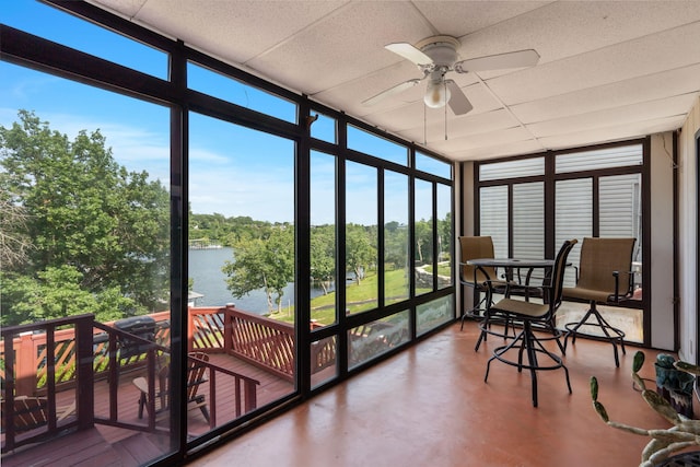6 Cedar Ln, Kimberling City, MO 65686 - sunroom featuring expansive windows, finished concrete floors, a paneled ceiling, view of wooded area, and a deck with water view