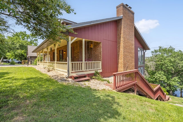 6 Cedar Ln, Kimberling City, MO 65686 - view of side of property featuring a porch, a chimney, a lawn, and brick siding