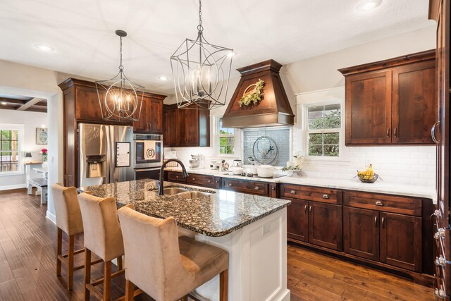 403 S 3rd St, Ozark, MO 65721 - kitchen with a sink, stainless steel appliances, custom exhaust hood, a chandelier, and dark stone counters