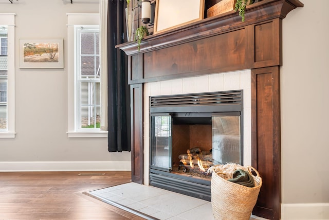 403 S 3rd St, Ozark, MO 65721 - detailed view of baseboards, a tile fireplace, and wood finished floors