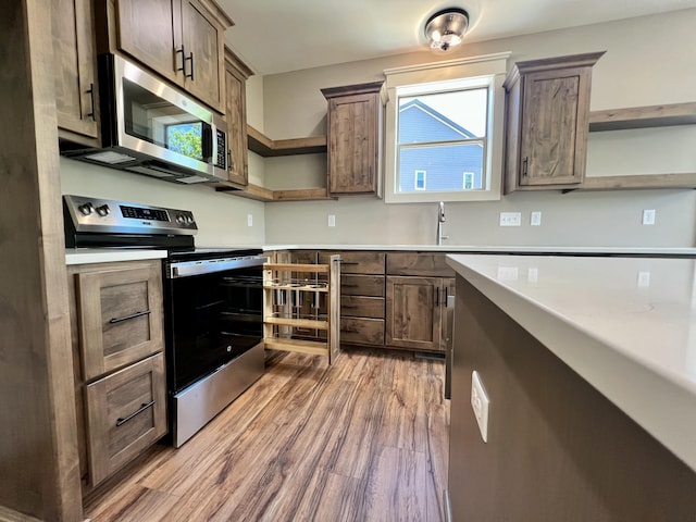 409 Silverwood Cir, Branson West, MO 65737 - kitchen featuring open shelves, appliances with stainless steel finishes, light wood-style floors, and light countertops
