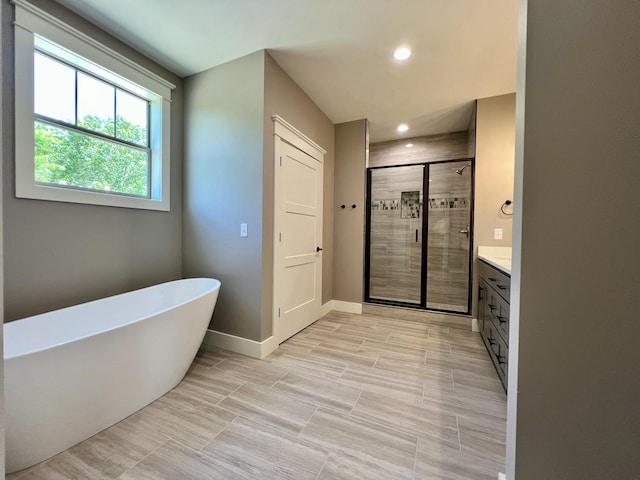 409 Silverwood Cir, Branson West, MO 65737 - full bathroom with a freestanding bath, vanity, a stall shower, recessed lighting, and baseboards