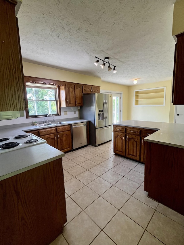 194 State Highway T, Oldfield, MO 65720 - kitchen featuring stainless steel appliances, a sink, light tile patterned flooring, light countertops, and a textured ceiling
