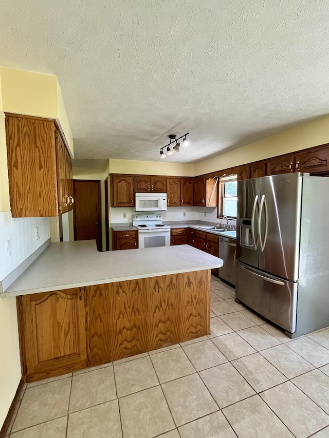 194 State Highway T, Oldfield, MO 65720 - kitchen with appliances with stainless steel finishes, a peninsula, a textured ceiling, light countertops, and light tile patterned flooring