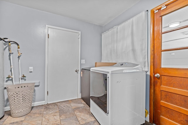 1103 4th St, Monett, MO 65708 - laundry room with washing machine and clothes dryer, light stone finish floors, and baseboards
