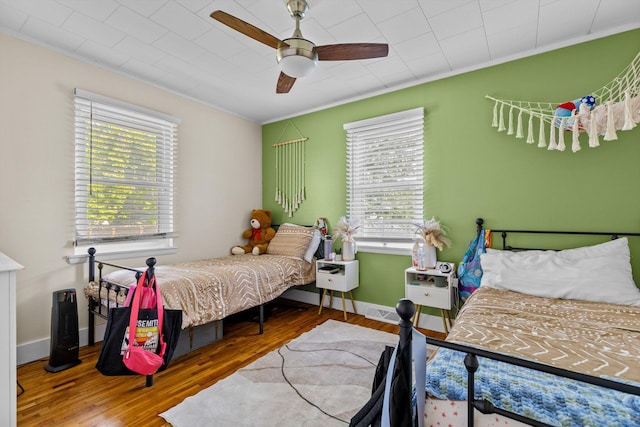 1103 4th St, Monett, MO 65708 - bedroom with ornamental molding, multiple windows, wood finished floors, a ceiling fan, and baseboards