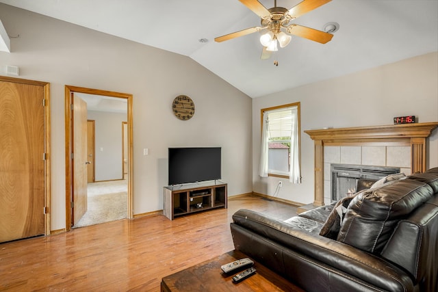 849 S Mahn Ave, Springfield, MO 65802 - living area with light wood-type flooring, a ceiling fan, lofted ceiling, a tile fireplace, and baseboards