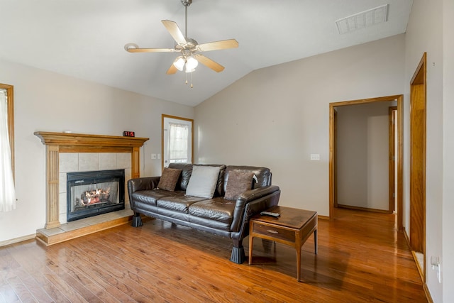 849 S Mahn Ave, Springfield, MO 65802 - living area featuring wood finished floors, a ceiling fan, a tile fireplace, vaulted ceiling, and baseboards