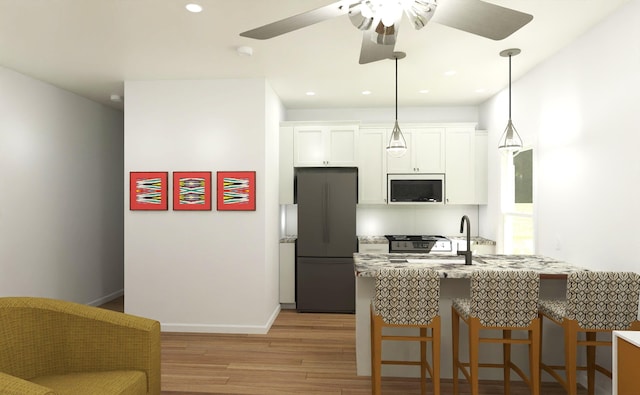 716-718 W Division St, Springfield, MO 65803 - kitchen featuring freestanding refrigerator, a ceiling fan, white cabinets, light wood finished floors, and a kitchen breakfast bar