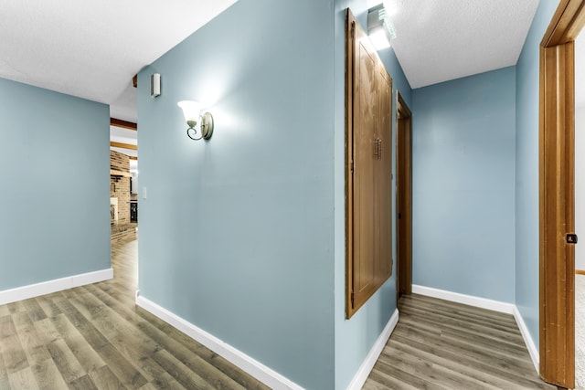 1061 Brentwood Dr, Marshfield, MO 65706 - hall with wood finished floors, baseboards, and a textured ceiling