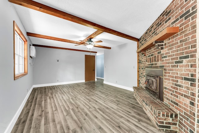 1061 Brentwood Dr, Marshfield, MO 65706 - unfurnished living room with baseboards, wood finished floors, beam ceiling, ceiling fan, and a wood stove