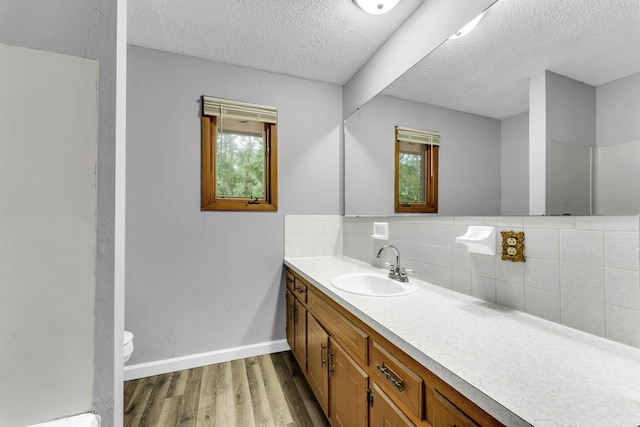 1061 Brentwood Dr, Marshfield, MO 65706 - bathroom with toilet, decorative backsplash, wood finished floors, vanity, and a textured ceiling
