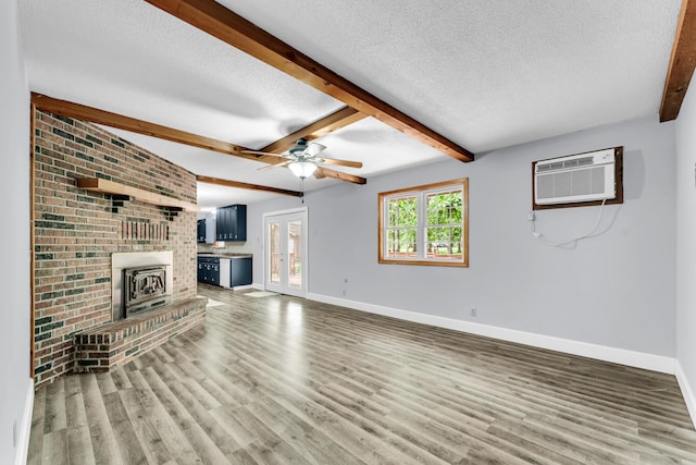 1061 Brentwood Dr, Marshfield, MO 65706 - unfurnished living room featuring baseboards, a wall unit AC, a textured ceiling, light wood finished floors, and beam ceiling