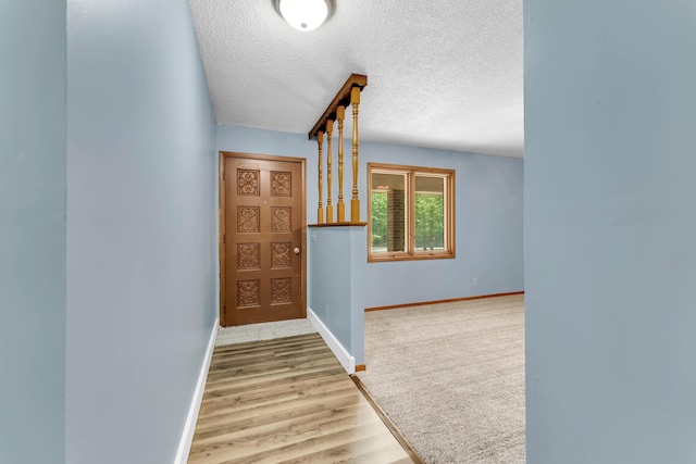1061 Brentwood Dr, Marshfield, MO 65706 - hall featuring wood finished floors, baseboards, and a textured ceiling