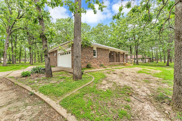 1061 Brentwood Dr, Marshfield, MO 65706 - view of property exterior featuring brick siding, driveway, and a garage