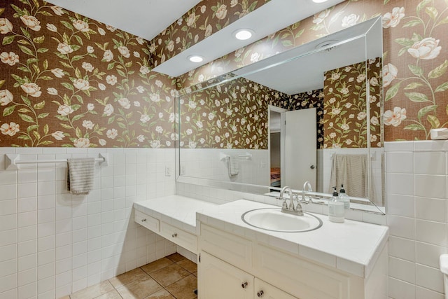 2215 E Rosebrier St, Springfield, MO 65804 - bathroom with wallpapered walls, wainscoting, vanity, tile walls, and tile patterned flooring