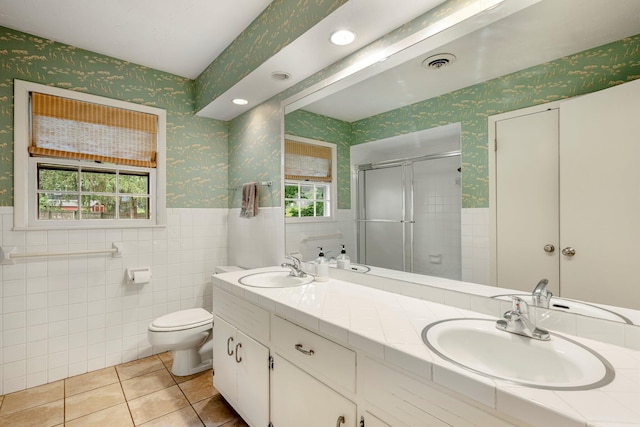 2215 E Rosebrier St, Springfield, MO 65804 - bathroom with wallpapered walls, tile patterned flooring, a shower stall, double vanity, and tile walls