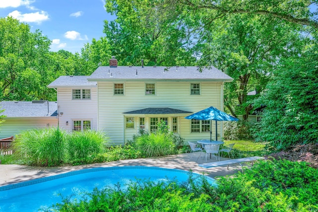 2215 E Rosebrier St, Springfield, MO 65804 - rear view of property featuring a chimney, a patio area, and an outdoor pool
