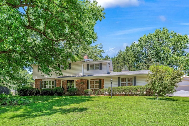 2215 E Rosebrier St, Springfield, MO 65804 - traditional home with a front yard, brick siding, a chimney, and an attached garage