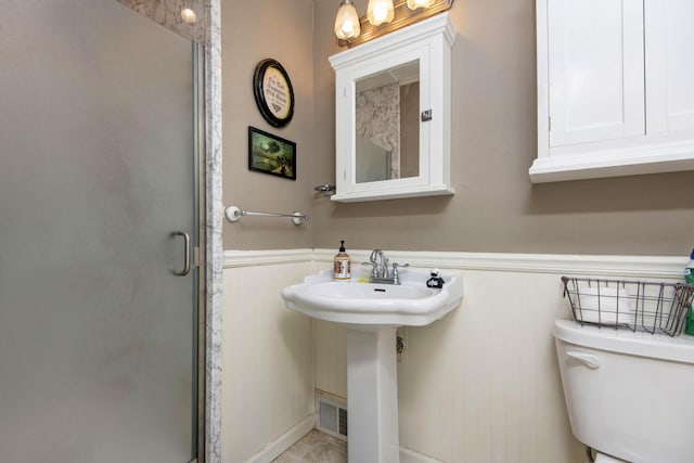 2344 E Manchester St, Springfield, MO 65804 - bathroom featuring wainscoting, toilet, a stall shower, and a sink